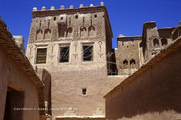 Image du Maroc Professionnelle de  La Kasbah de Taourirt fut édifiée au 17ème siècle par la tribu des Glaoui, située sur une colline au centre urbain de la ville d'Ouarzazate, cette remarquable ancienne bâtisse en pisé parfaitement conservée est l'une des plus belles constructions architecturales de la ville. La Kasbah qui ressemble à un grand château de sable incrusté dans le désert, fait partie du circuit touristique, elle a été classé Patrimoine Mondiale de l’Unesco. Ce véritable joyau de Ouarzazate permet au visiteur de découvrir l’intérieur d’une ksar où résident souvent la population berbères du sud du Maroc. Photo datant du Samedi 23 Août 1997. (Photo / Abdeljalil Bounhar) 